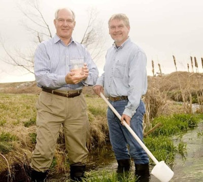 Simmons Foods Chairman Mark Simmons and Director of Environmental Quality Andy Brashear take water samples downstream from the Southwest City plant.