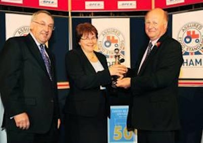 Meryl Ward is presented with the latest David Black Award for services to the British pig industry by UK farm minister Jim Paice (at right) and BPEX chairman Stewart Houston.