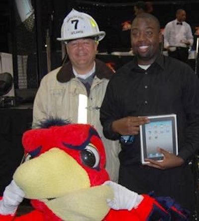 Rodney Ray received an Apple iPad after winning the 2011 FoodFight “Can You Take the Heat?” Wing Competition at the International Poultry Expo and International Feed Expo. The award was presented to Ray by Mark Sussman (left), director of trade show sales, Atlanta Convention and Visitors Bureau. Harry the Hawk was also in attendance.