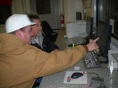 Control room of NuWest Feed Mill with Production Manager Geoff Holland reviewing production data with shift supervisor