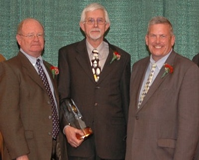 Steve Hilleson, left, Centurion Poultry Inc. project manager, and Gijs Schimmel, president of Centurion Poultry Inc. stand with Iowa Secretary of Agriculture Bill Northey after accepting the Outstanding Business of the Year Venture Award in recognition of outstanding business achievement in Iowa.