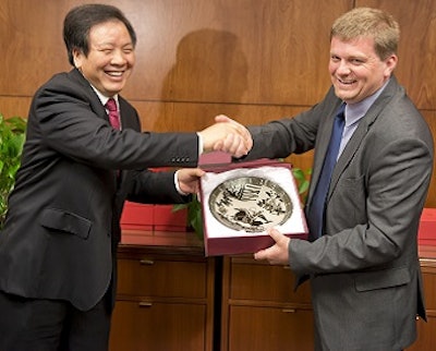 Zhou Benshun, party secretary of Hebei province and Hy-Line International President Jonathan Cade exchange cultural gifts.