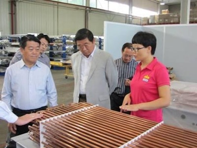Customers inspecting the heating coils of the Gold Line environmental control unit in Jamesway’s new production facility in Beijing, China.