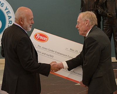 John Tyson, left, chairman of Tyson Foods, presents a ceremonial check for $2 million on behalf of the Tyson Family Foundation to Ed Clifford, president and CEO of The Jones Center and Jones Trust.