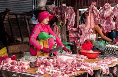 A woman works at a pork meat market in Cambodia. | photo by Perfect Lazybones | Big StockPhoto