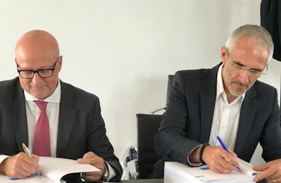 Jan Henriksen, left, CEO of Aviagen Broiler Breeding Group, and Frederic Grimaud, CEO of Groupe Grimaud, sign documents related to Aviagen's pending acquisition of Hubbard Breeders. | Aviagen