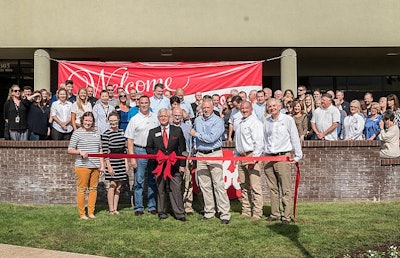 Cobb-Vantress President Joel Sappenfield cuts the ribbon in front of the company’snew office location in downtown Siloam Springs, Arkansas. | Photo courtesy of Cobb-Vantress