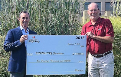 Jayson Penn, president of Pilgrim’s USA, presents a ceremonial check to Jerry Moye, Hendrix Genetics, and current USPOULTRY Foundation chairman. | Photo courtesy of USPOULTRY