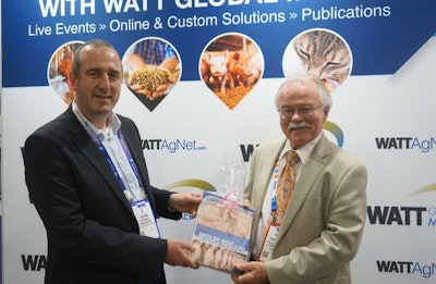 Ton van Schie, managing director of Roodbont Publishers, presents a copy of the book, 'Broiler Meat Signals' to outgoing U.S. Poultry & Egg Association chairman Tom Hensley. (Deven King)