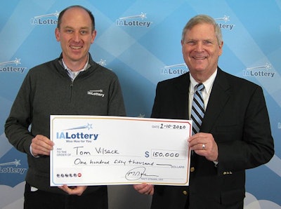 Matt Strawn, left, Iowa Lottery CEO, presents former U.S. Secretary of Agriculture Tom Vilsack with a replica check, representing Vilsack’s $150,000 Powerball prize. (Iowa Lottery)