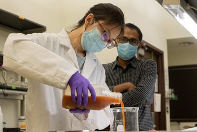Rice University undergraduate student Yufei 'Nancy' Cui prepares a solution based on protein from wasted eggs. The solution can be used as a coating that extends the freshness of fruit and vegetables. With her is Rice research scientist and mentor Muhammad Rahman. (Jeff Fitlow | Rice University)
