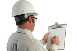 a construction safety inspector marking his checklist - full, over-the-shoulder view
