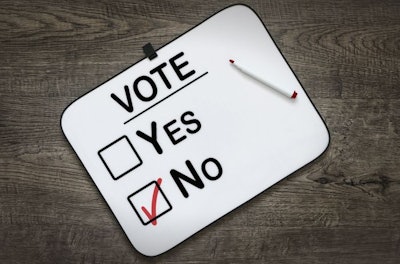White board with the word Vote,Yes and No Check boxes ,on a dark wooden background