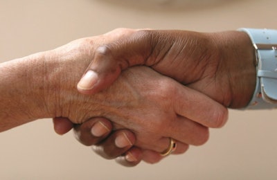 Helping hand shakes another hand as part of an agreement