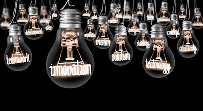 Large group of light bulbs with shining fibers in a shape of INNOVATION and IDEA concept related words isolated on black background; horizontal composition