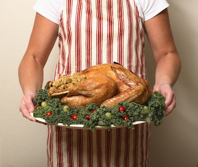 Person in Apron holding Turkey