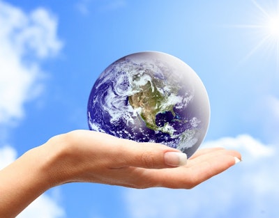 Globe in human hand against blue sky. Environmental protection concept.