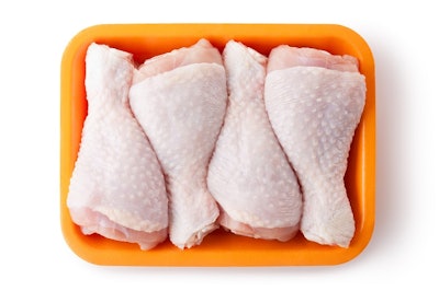 Fresh chicken legs on the retail tray. Top view. Isolated on a white.