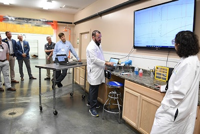 The Salvus team shows how the target substance is detected using the flow cartridge and handheld device for guests during the Salvus open house on Nov. 3 in Valdosta, Ga.
