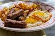 Fried sunny side up American egg breakfast with sausage and home fries
