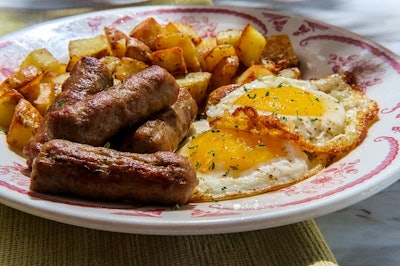 Fried sunny side up American egg breakfast with sausage and home fries