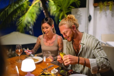 Caucasian couple having a dinner at the restaurant during their vacation. Man eating tacos