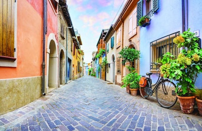 Narrow street of the village of fishermen San Guiliano with colorful houses and a bicycle in early morning in Rimini, Italy