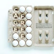 Paper egg carton with white eggs and conceptual word, CAGE FREE, isolated on white background.