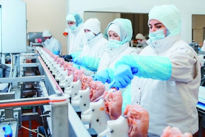 Group of workers working at a chicken factory - food processing plant concepts.Automated production line in modern food factory. Ravioli production. People working.Production line in the food factory.Meat processing plant.