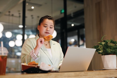 Business Woman Eating Chicken